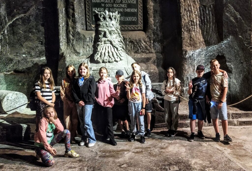 Na zdjęciu Komora K. Wielkiego - kopalnia soli w Wieliczce. Uczniowie pozują przed pomnikiem.
