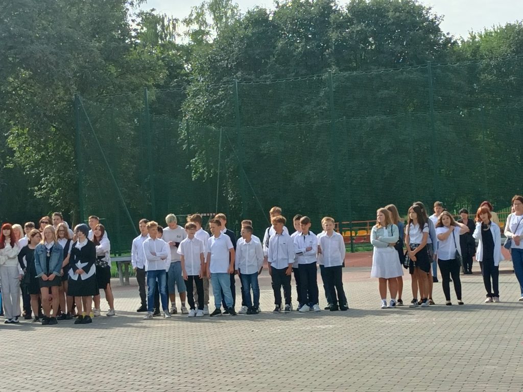 Zdjęcie przedstawia uczniów na uroczystości rozpoczęcia roku szkolnego na placu przed szkołą 