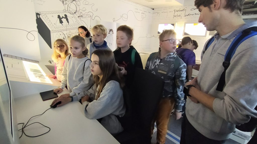 zdjęcie przedstawia uczniów w czasie zwiedzania wystawy w Centrum Komiksu i Narracji Interaktywnej