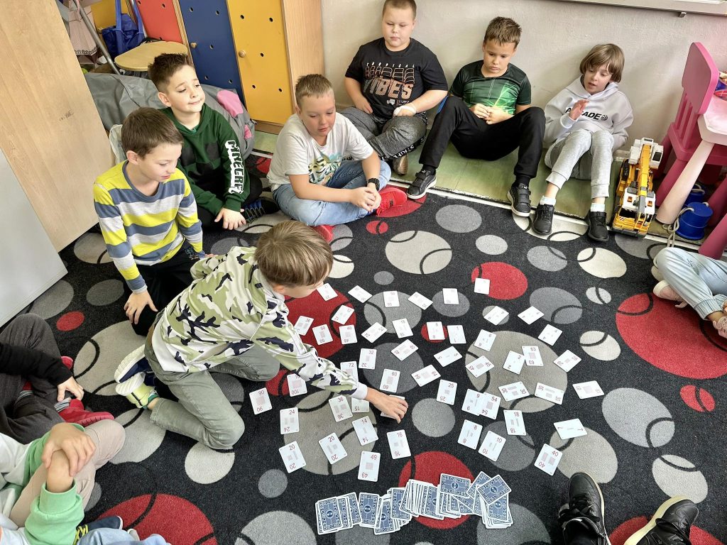 zdjęcie przedstawia uczniów podczas nauki poprzez zabawę z tabliczką - karty Grabowskiego