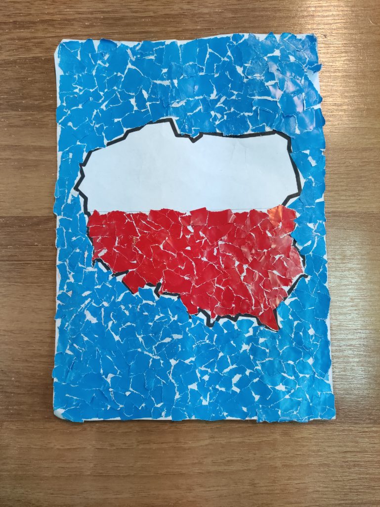 kształt polski wyklejony na biało czerwono na niebieskim tle. Całość wyklejona kolorowym papierem.