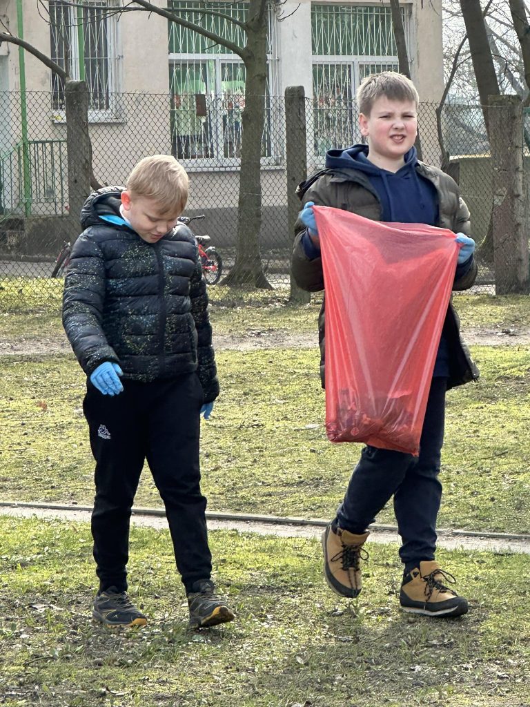 na zdjęciu chłopiec trzyma worek na śmieci