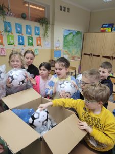 na zdjęciu widzimy uczniów wyciągających piłki do nogi