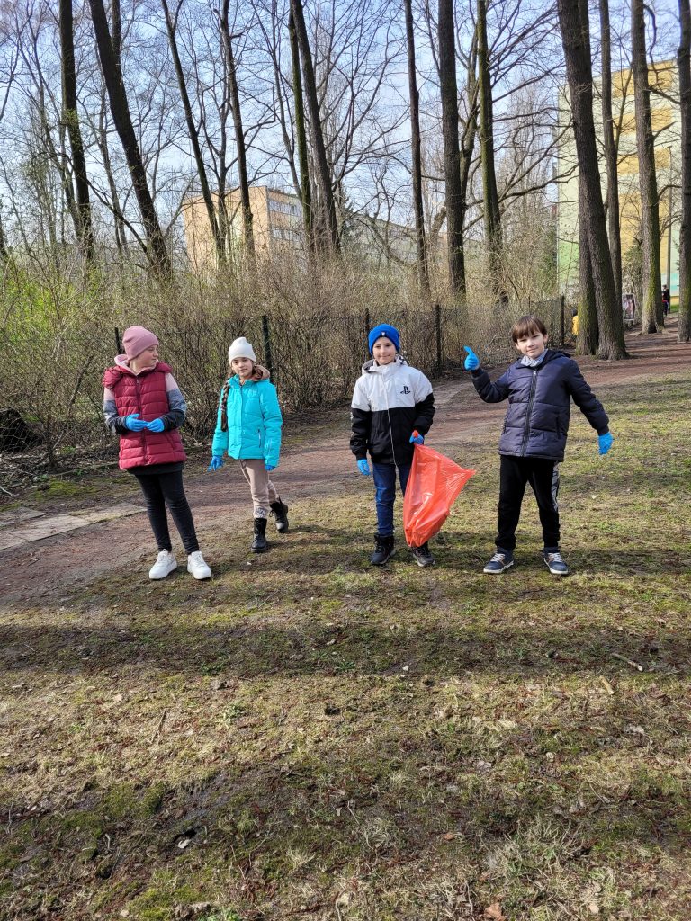 widzimy na zdjęciu dzieci w parku gotowe do sprzątania