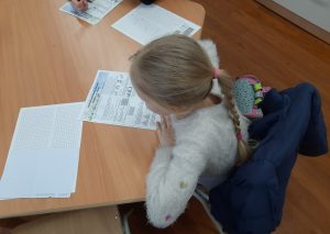 zdjęcie przedstawia uczniów piszących zadania konkursowe