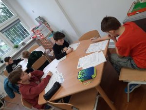 zdjęcie przedstawia uczniów piszących zadania konkursowe