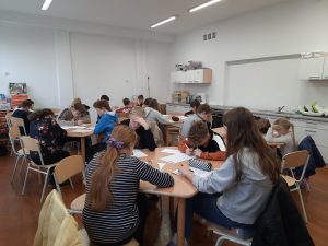 zdjęcie przedstawia uczniów piszących zadania konkursowe
