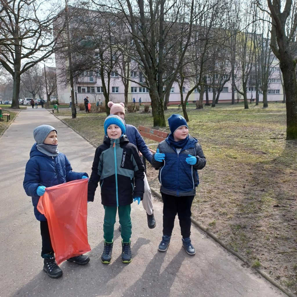 na zdjęciu widzimy dzieci zbierające śmieci
