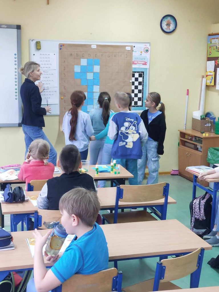 zdjęcie przedstawia jak uczennice tworzą rysunek z niebieskich karteczek