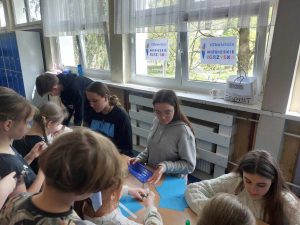 Zdjęcie przedstawia stoisko na którym uczniowie przekazują hasła wspierające