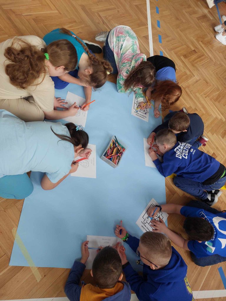 zdjęcie przedstawia jak dzieci na podłodze wykonują prace