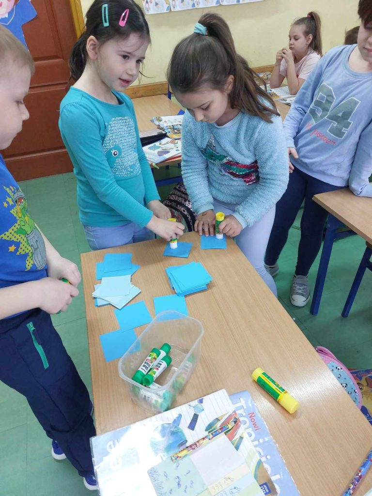 zdjęcie przedstawia jak uczennice biorą niebieskie karteczki
