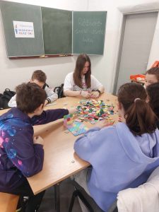 Zdjęcie przedstawia jak uczniowie budują z klocków