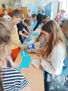 Zdjęcie przedstawia jak uczniowie czytają hasła motywacyjne o autyzmie