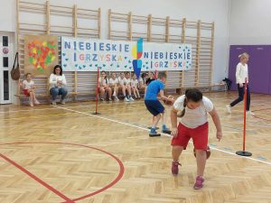 zdjęcie przedstawia uczniów podczas brania udziału w turnieju- dyscyplina-odbijanie piłki do kosza w biegu