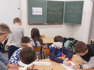 zdjęcie przedstawia jak uczniowie rozwiązują zadania z zamkniętymi oczyma.