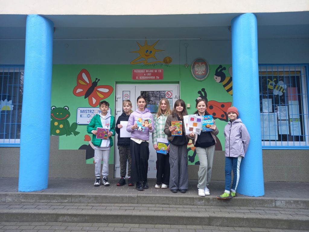 zdjęcie przedstawia uczniów z książkami przed przedszkolem