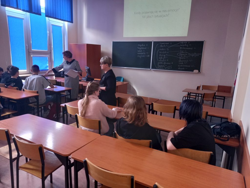 Zdjęcie przedstawia jak panie prowadzące warsztaty tłumaczą coś uczniom