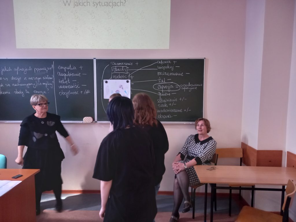 Zdjęcie przedstawia jak panie prowadzące warsztaty tłumaczą coś uczniom