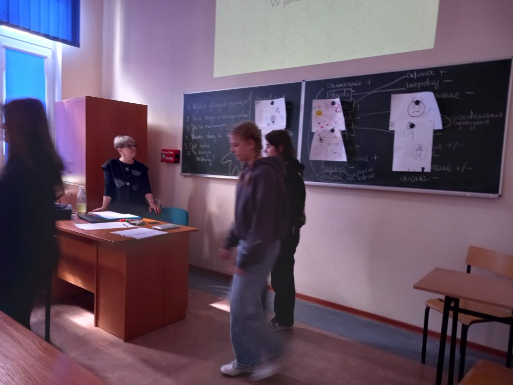 Zdjęcie przedstawia jak panie prowadzące warsztaty tłumaczą coś uczniom