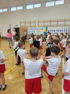 uczniowie na sali gimnastycznej rozciągają się i przygotowują na igrzyska