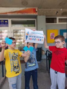 Zdjęcie przedstawia uczniów trzymających plakat niebieskie igrzyska