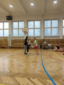 Uczeń odbiera na zdjęciu dyplom po igrzyskach