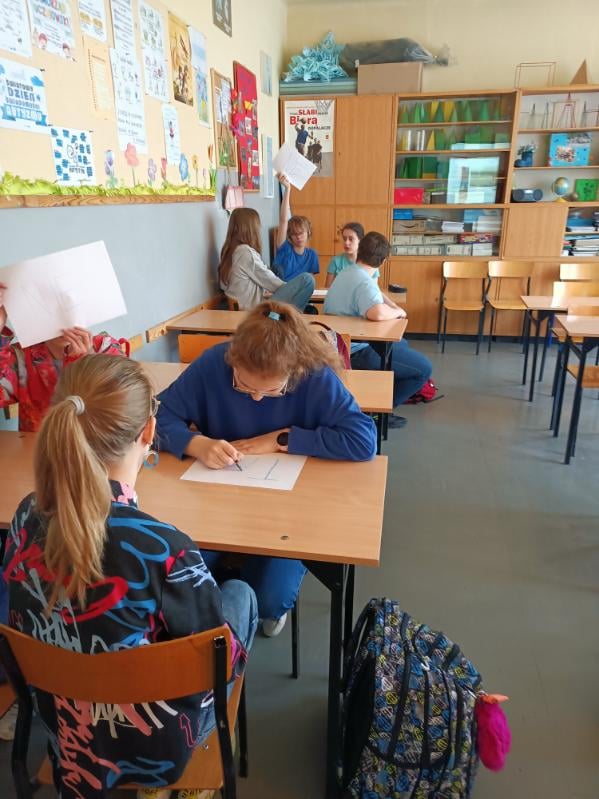 zdjęcie przedstawia jak uczennice rozwiązują zadania na kartce