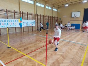 zdjęcie przedstawia uczniów podczas brania udziału w turnieju- dyscyplina-odbijanie piłki do kosza wokół drążka