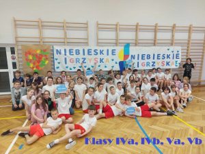 zdjęcie grupowe uczniów pod banerem niebieskie igrzyska IV a IVb Va Vb