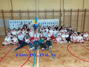 zdjęcie grupowe uczniów pod banerem niebieskie igrzyska IVc IVd Vc