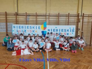 zdjęcie grupowe uczniów pod banerem niebieskie igrzyska VIIa VIIb VIId