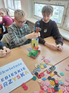 Zdjęcie przedstawia jak uczniowie budują z klocków