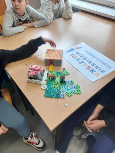 Zdjęcie przedstawia budowlę z klocków i plakat 2 kwietnia niebieskie igrzyska