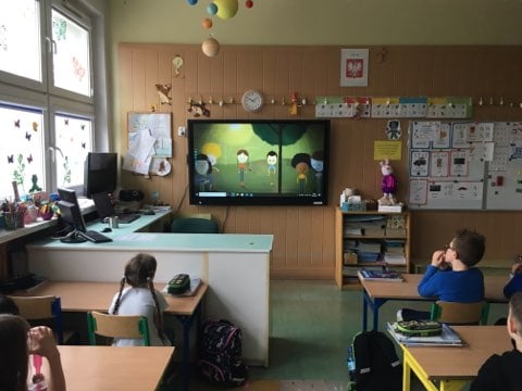 zdjęcie przedstawia jak dzieci oglądają film