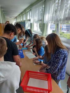 Zdjęcie przedstawia uczniów losujących złote myśli o autyźmie