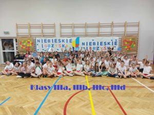 zdjęcie grupowe uczniów pod banerem niebieskie igrzyska IIIa IIIb IIIc IIId