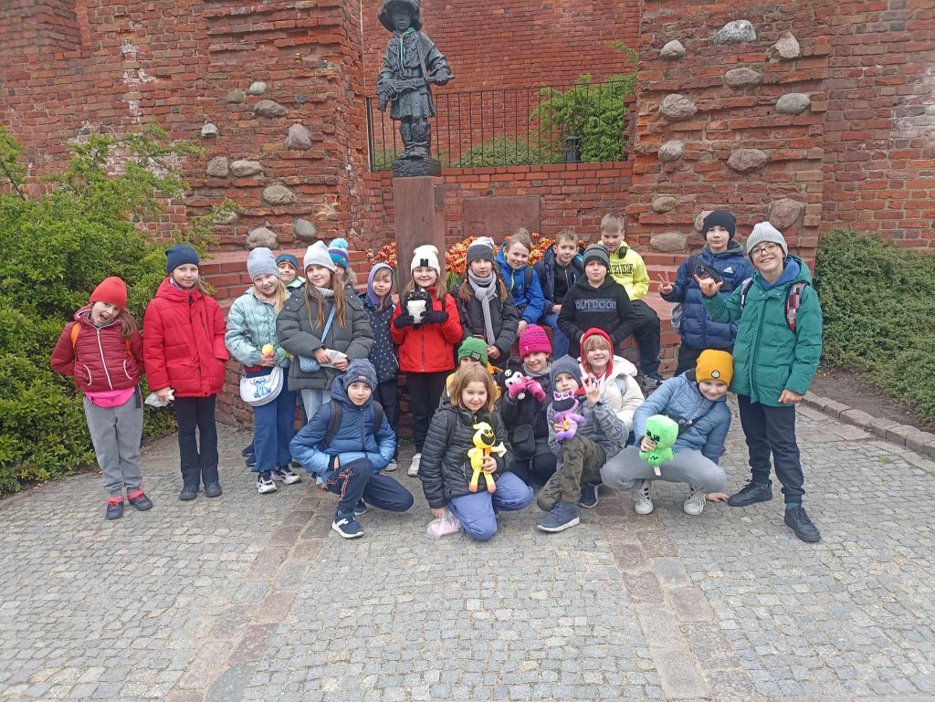 zdjęcie grupowe uczniów pod pomnikiem małego powstańca