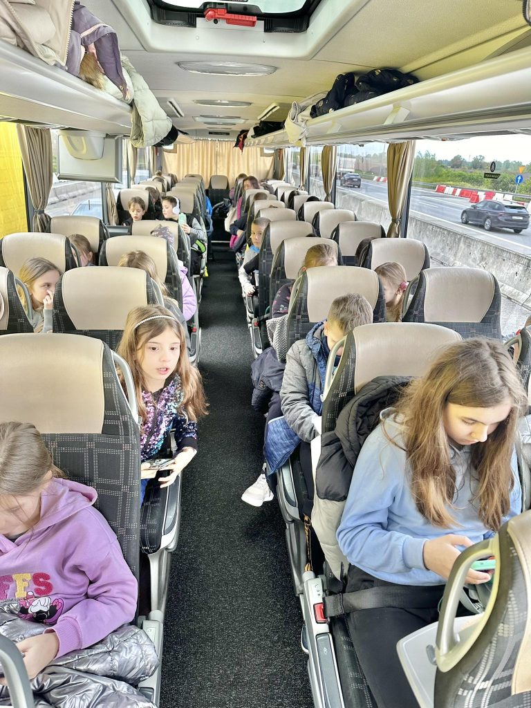 zdjęcie przedstawia uczniów siedzących w autokarze