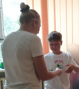 dyplom jest wręczany uczniowi przez nauczycielkę 