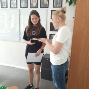 dyplom jest wręczany uczennicy przez nauczycielkę 
