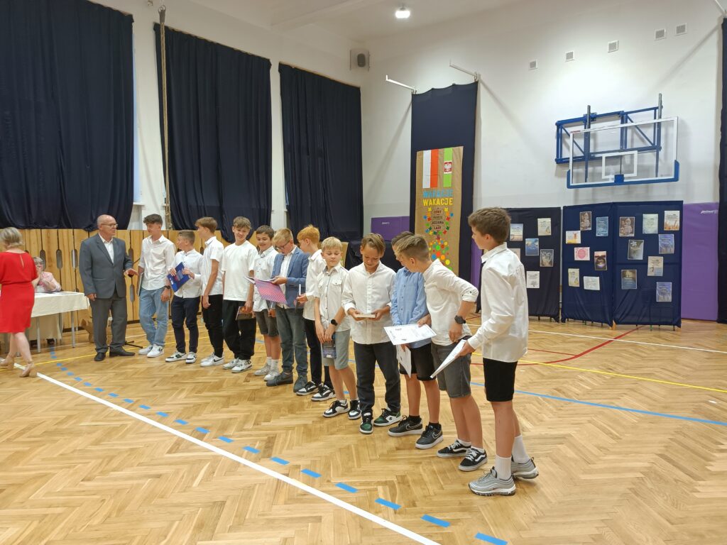 wyróżnieni uczniowie dostają nagrody na apelu