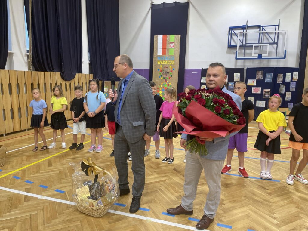 Przedstawiciele Rady Rodziców przemawiają do Pani Dyrektor, mają kwiaty i kosz prezentowy