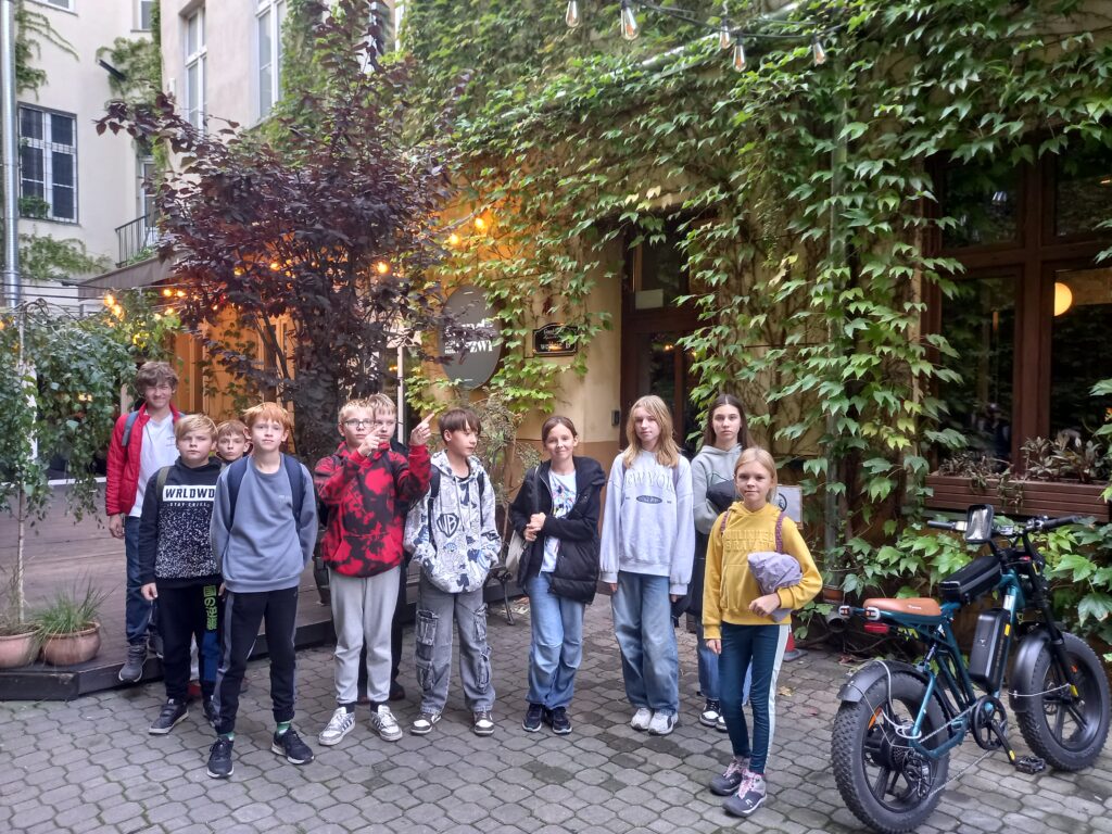 zdjęcie grupowe uczniów na tle zielonych pnączy