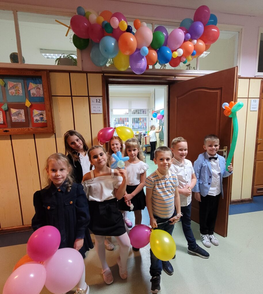 zdjęcie grupowe uczniów 1a przed klasa ubraną w balony