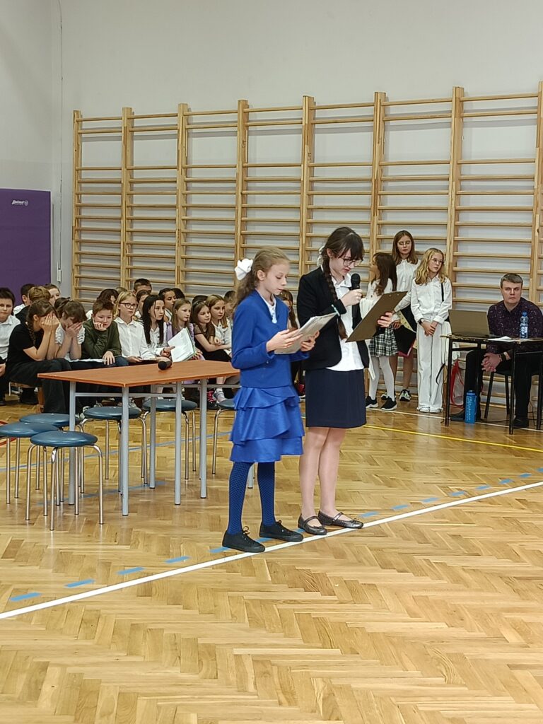 Uczennice witające dyrekcję, wszystkich nauczycieli i uczniów.