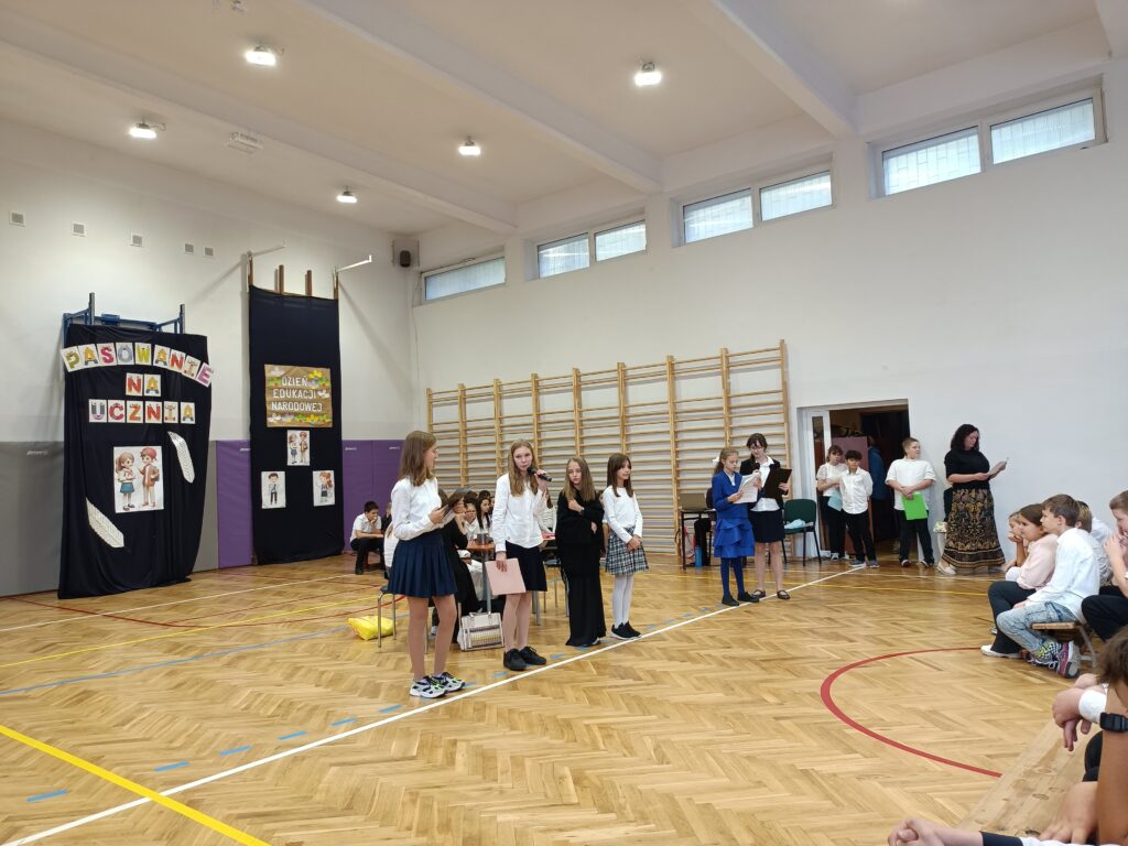 Uczennice przedstawiają w żartobliwy sposób style uczenia się, na drugim planie Pani Małgorzata Jastrzębska.