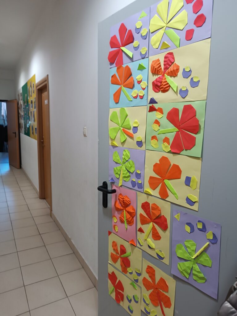 zdjęcie przedstawia drzwi przystrojone pracami technicznymi dzieci. Każda praca to kolorowe liście na kolorowych kartkach.
