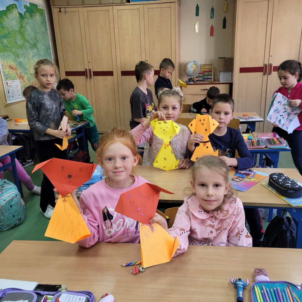 Dzieci prezentują swoje prace wykonane z papieru- pieski.