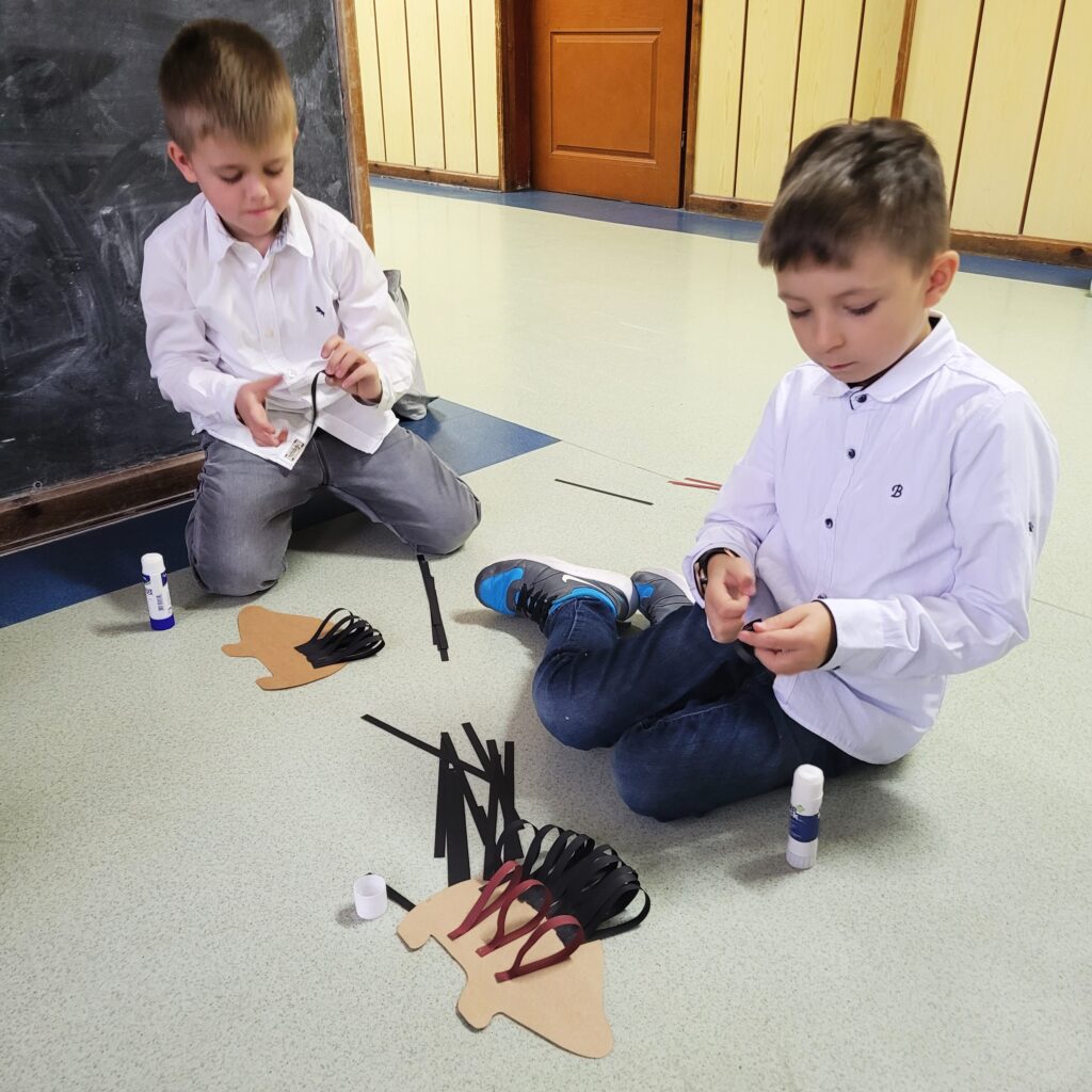 dzieci na zdjęciu wykonują pracę techniczną- robią jeża